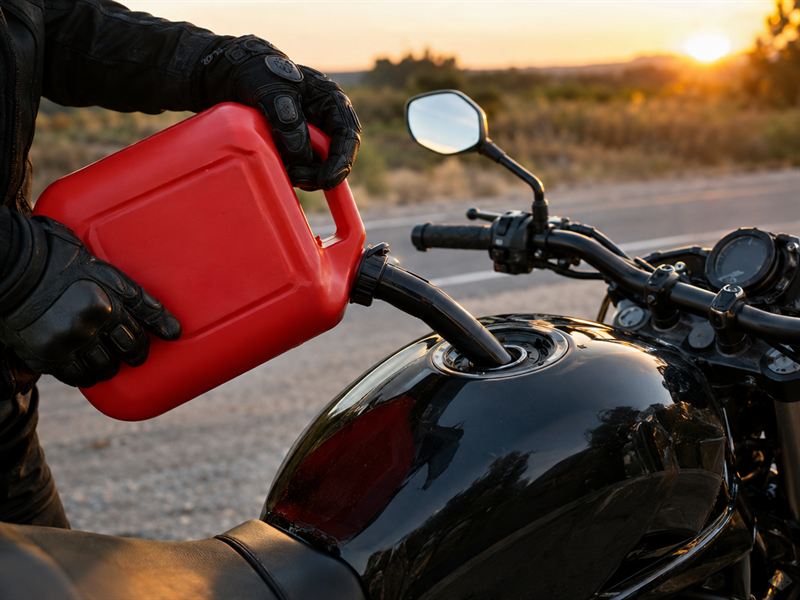 Gasolina sendo colocada no tanque de uma moto com galão